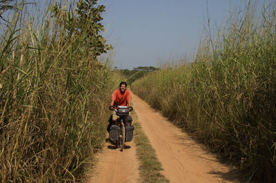 Rear view of man riding bicycle on road