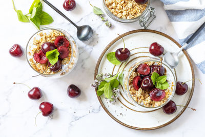 Healthy menu concept. home made granola breakfast. glass of parfait made of granola, berries cherry.