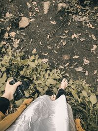 Low section of woman standing on leaves