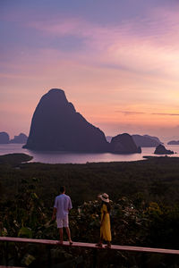 Rear view of people looking at sea against sky