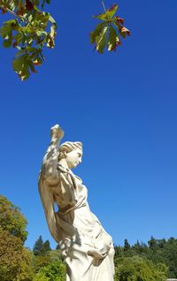 Low angle view of statue against blue sky