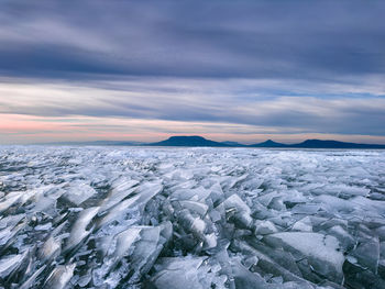 Scenic view of snow covered landscape against sky during sunset