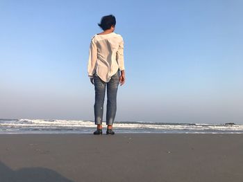 Rear view of man standing on beach