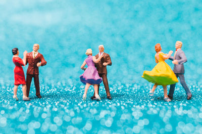Close-up of couples figurines on blue floor