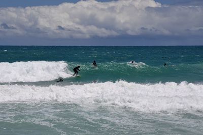 Surfers in the turquoise indian ocean waves at scarborough beach in perth, australia