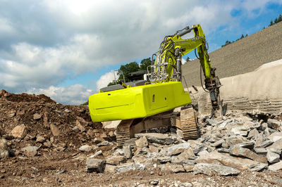 Yellow construction site by road against sky