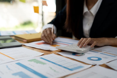 Midsection of business colleagues working on table