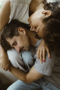 High angle view of romantic couple with eyes closed sitting together at home