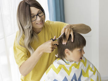 Mother cuts her son hair. new normal in quarantine of coronavirus covid-19. home lifestyle.