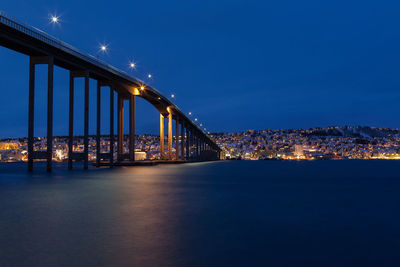 Illuminated tromso bridge over tromsoysundet strait at night