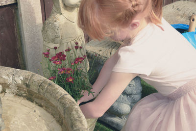 High angle view of girl planting flowers at back yard