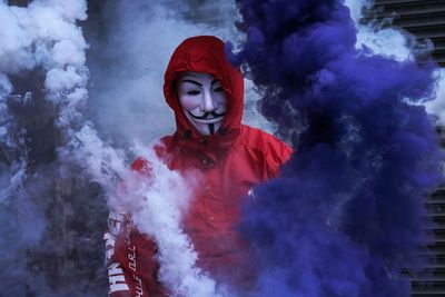 Man wearing mask standing amidst smoke