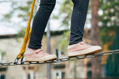 Low section of woman standing on railing