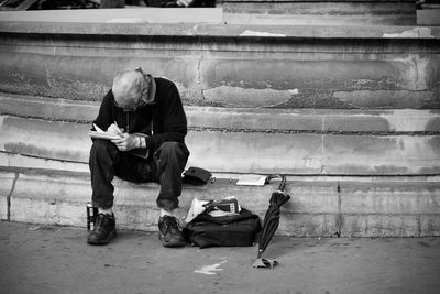 Senior man sitting on steps by footpath