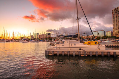 Sailboats in sea at sunset