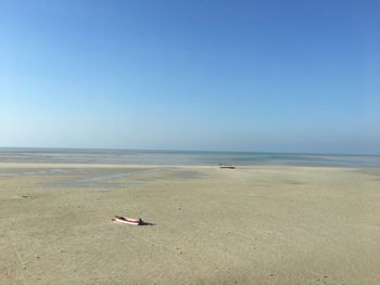 Scenic view of beach against clear blue sky