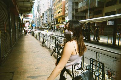 Portrait of young woman standing in city