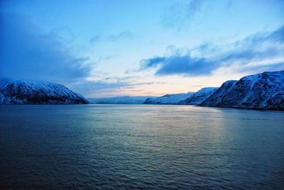 Scenic view of sea and snowcapped mountains against sky during sunset