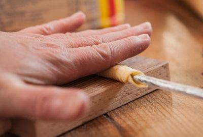 Close-up of cropped hand holding wood