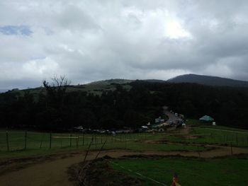 Scenic view of grassy field against cloudy sky