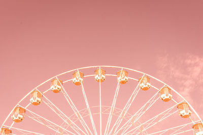 Low angle view of ferris wheel against pink sky