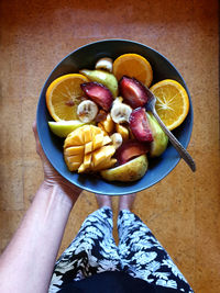 High angle view of hand holding fruits on table