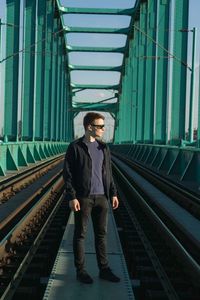 Man standing on railway bridge