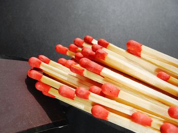 Close-up of wooden matchsticks on striking flint of matchbox