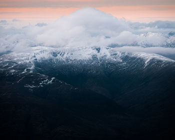 Aerial view of snowcapped mountains against sky during sunset