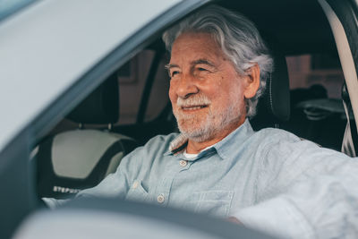 Smiling senior man sitting in car