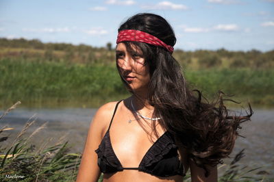 Young woman wearing bikini top looking away