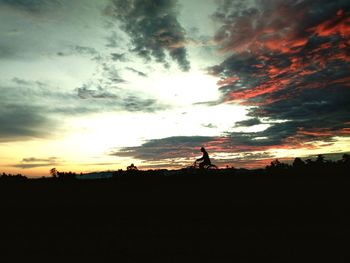 Scenic view of silhouette field against sky during sunset