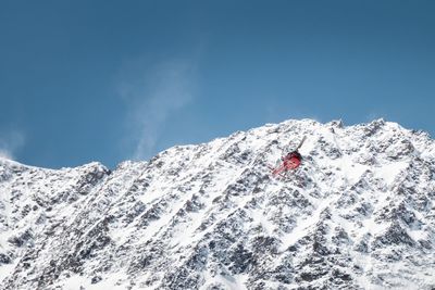 Person on snowcapped mountain against sky