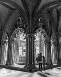 Rear view of woman with daughter standing in abbey