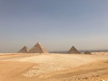 Pyramids on land against clear sky