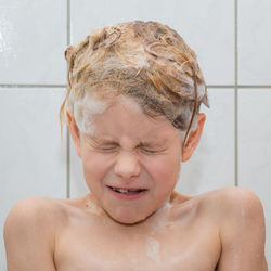 Portrait of shirtless boy in bathroom