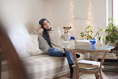 Woman sitting on sofa in living room