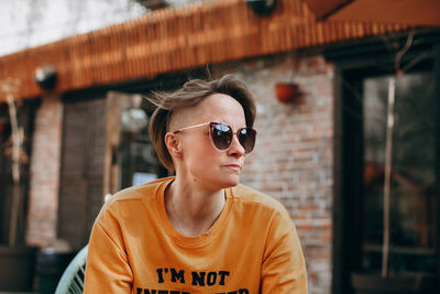 Beautiful young woman with short blond hair in casual clothing sitting and smiling.