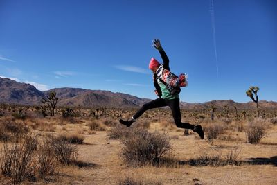 Full length of woman jumping in the desert