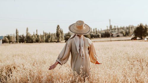 Woman with umbrella standing on field