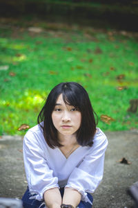 Portrait of young woman sitting outdoors