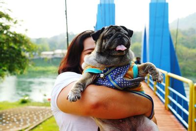 Midsection of woman with dog sitting outdoors