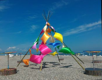 Multi colored umbrellas on beach against blue sky