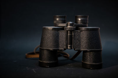 Close-up of camera on table against black background