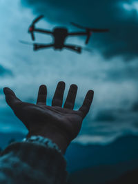 Close-up of hand against sky