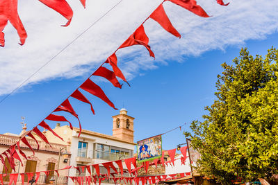 Low angle view of flags hanging against sky