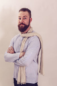 Portrait of young man standing against wall