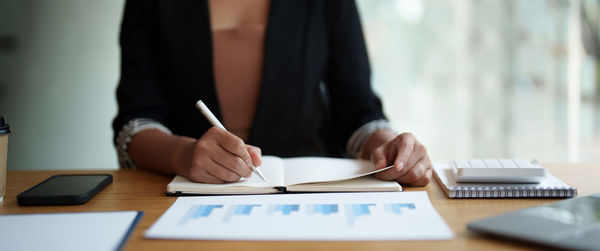 Midsection of businessman working on table