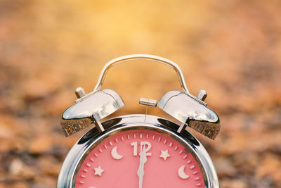 Cropped image of alarm clock on field