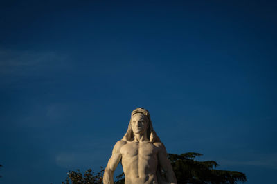 Low angle view of statue against blue sky